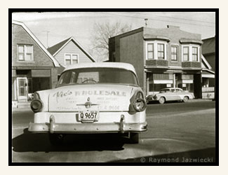 Vic's Wholesale Salesmen's car, with the former smoke shop building in the background.